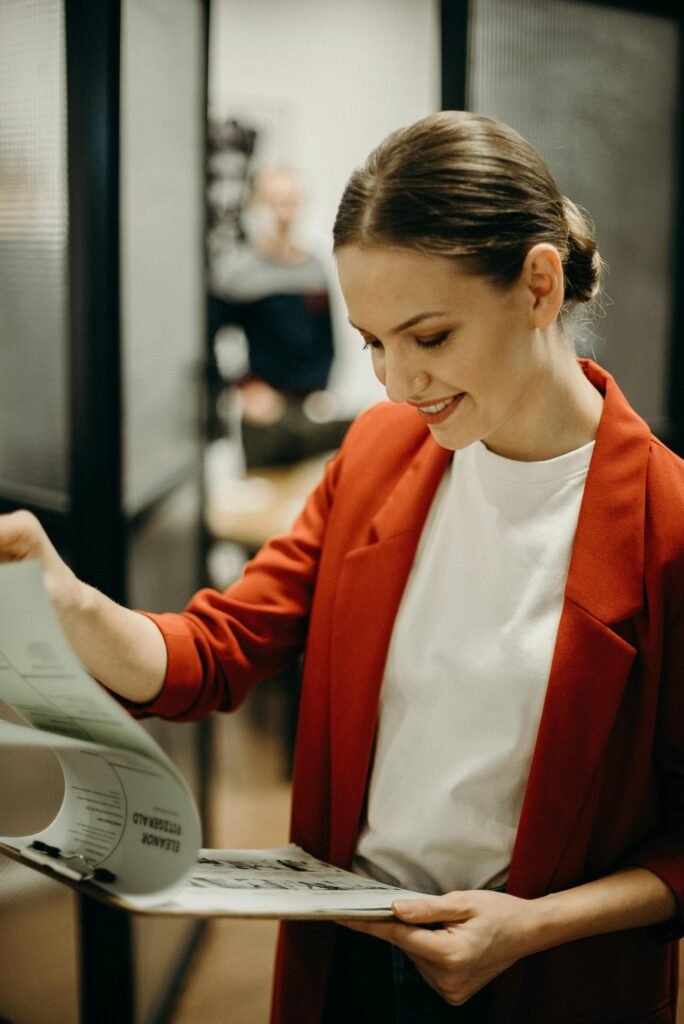 Confident businesswoman reading documents in the office with a smile.